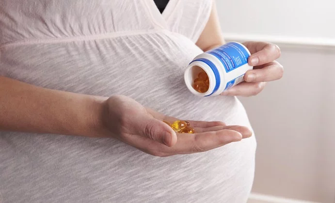 detail of pregnant woman taking vitamins