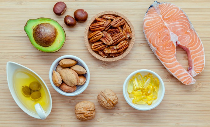 selection food sources of omega 3 and unsaturated fats. super food high omega 3 and unsaturated fats for healthy food. almond ,pecan ,hazelnuts,walnuts ,olive oil ,fish oil ,salmon and avocado on wooden background .