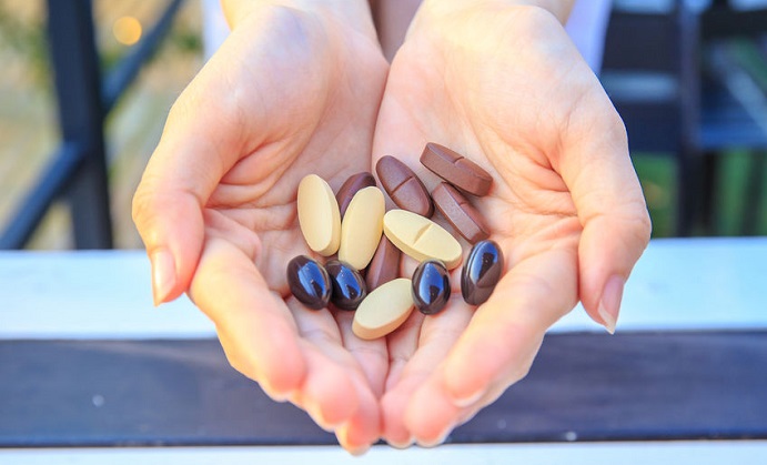 closeup to multivitamin tablets on two hand of pretty women or girl.