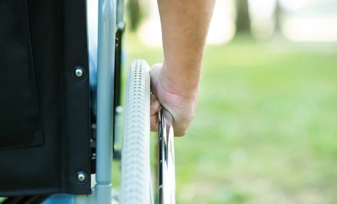 detail of a man using a wheelchair in a park